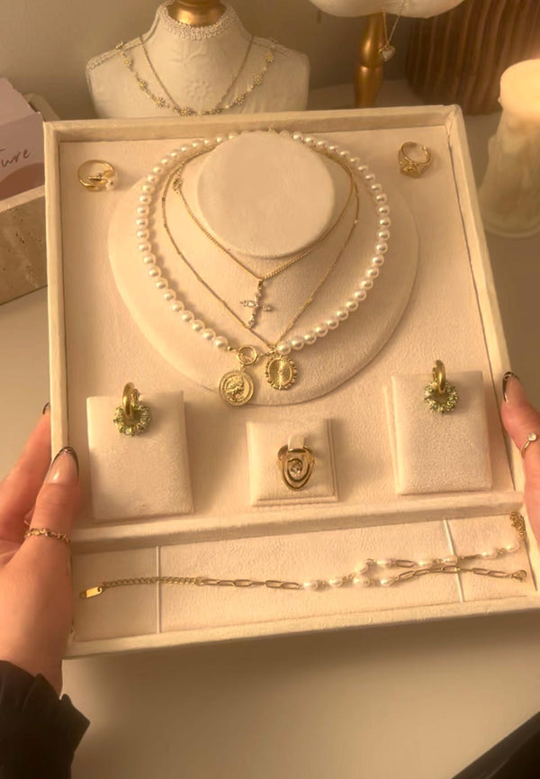 Jewelry set including necklaces, earrings, and bracelets displayed in a box.