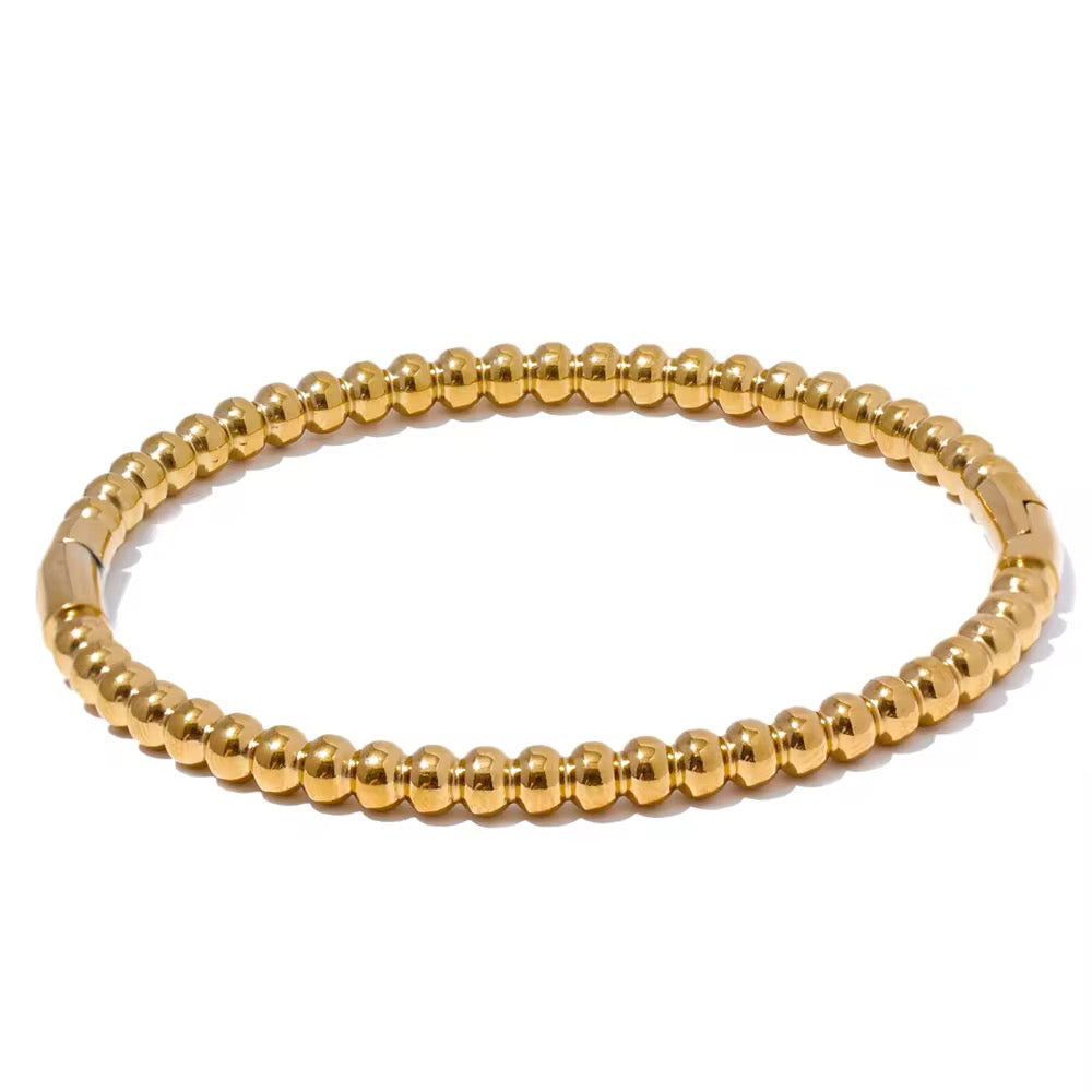 Gold beaded lida bangle on a white background
