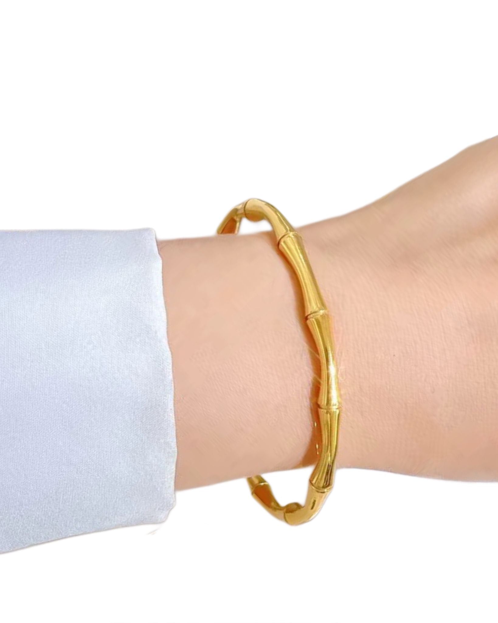 Gold bracelet on a wrist with a white background