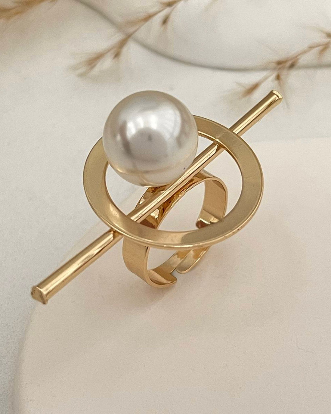 Gold ferra pearl ring with a pearl on a light background