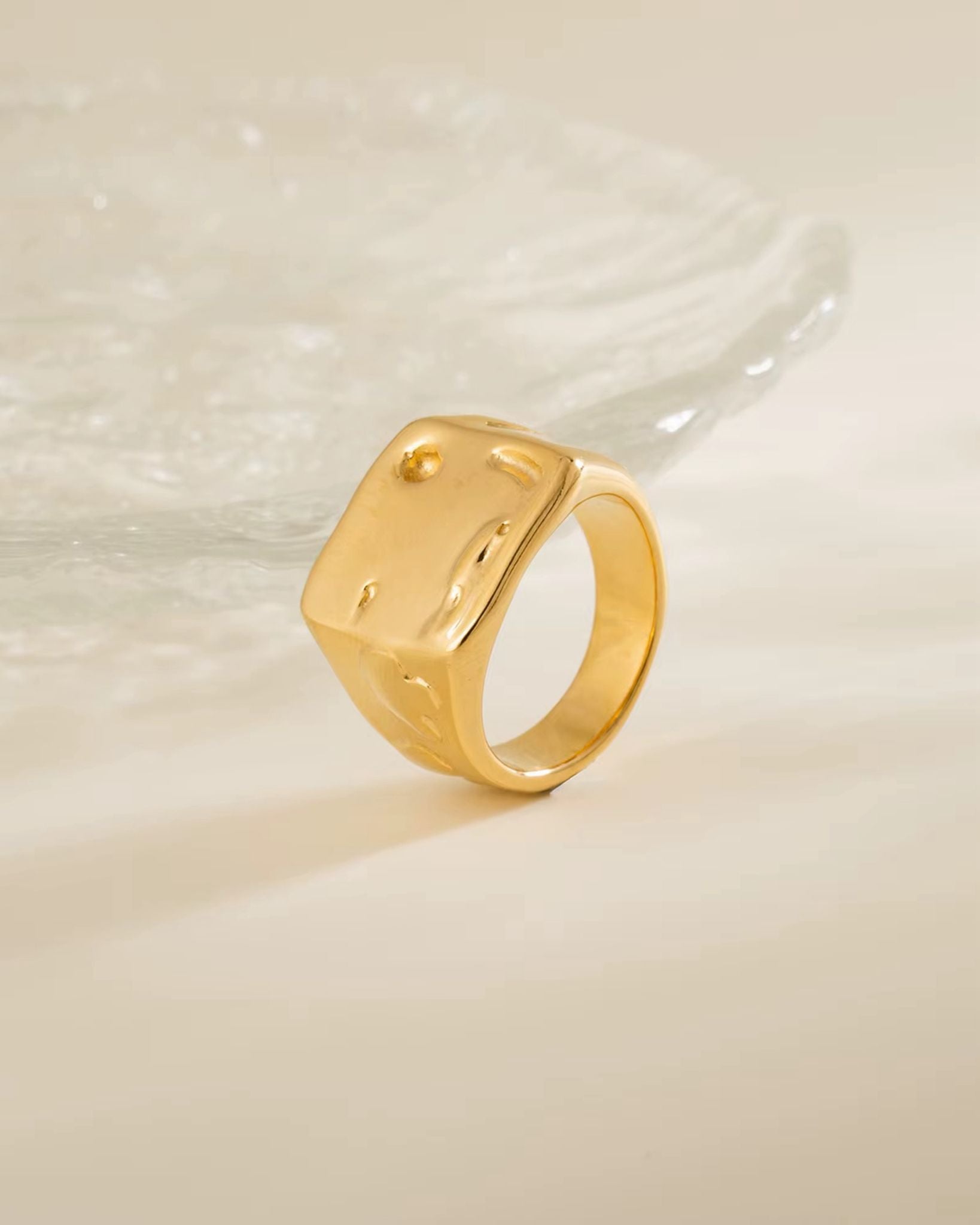 Goldy ring on a textured beige background