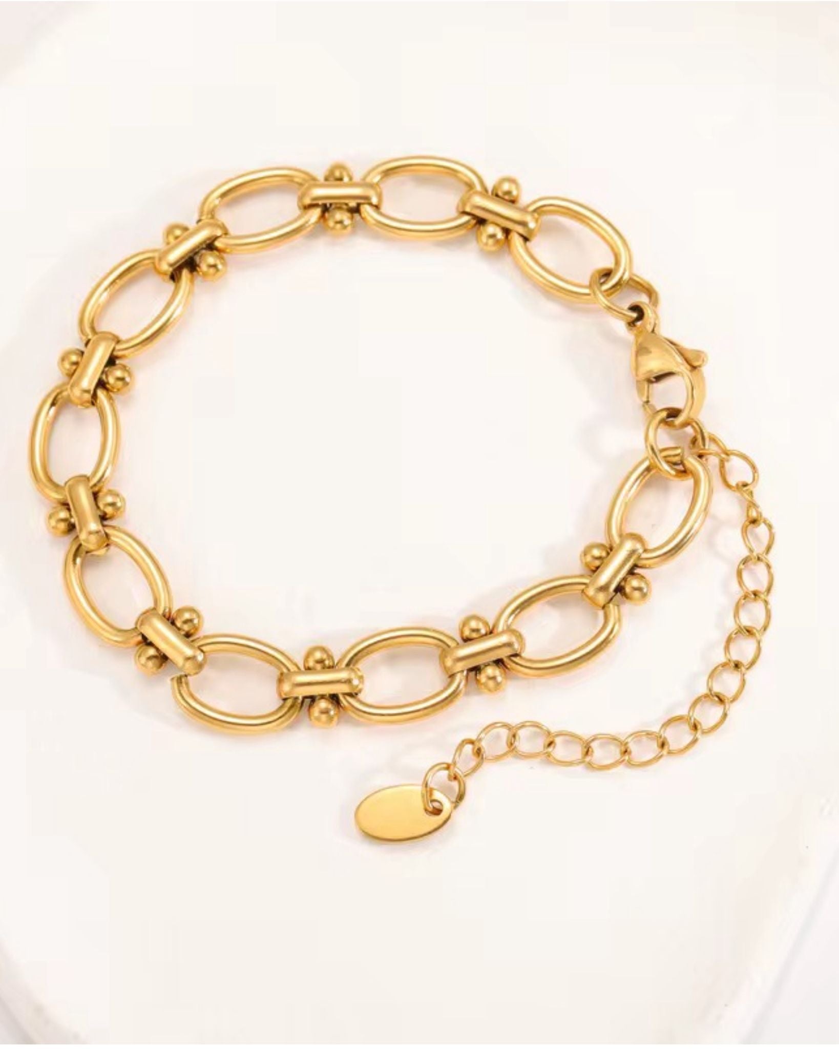 Gold block chain bracelet on a white background