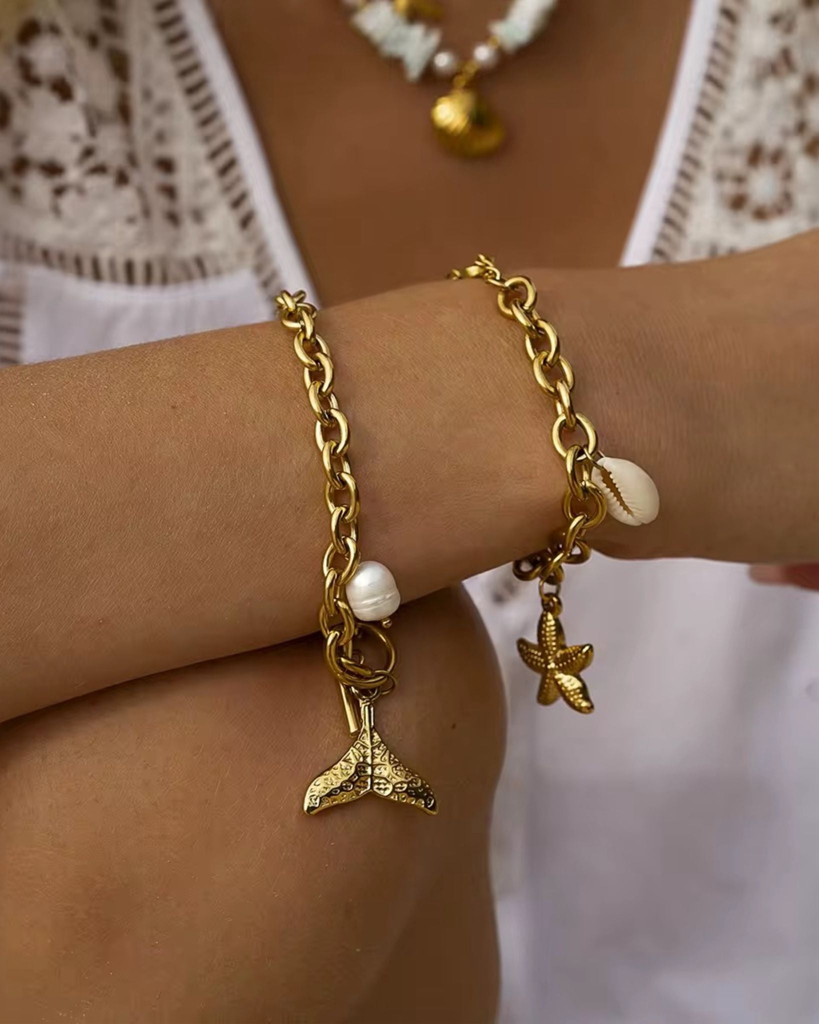 Gold bracelet with mermaid tail and starfish charm on a wrist