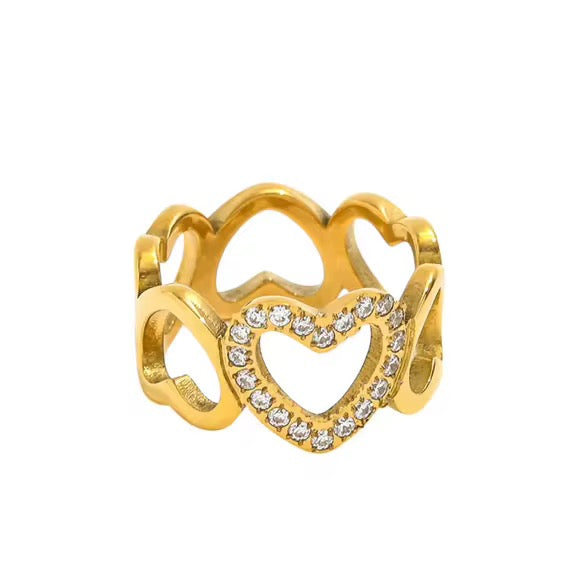 A gold-colored brielle heart ring with a heart-shaped cutout adorned with cubic zirconia, displayed against a white background.