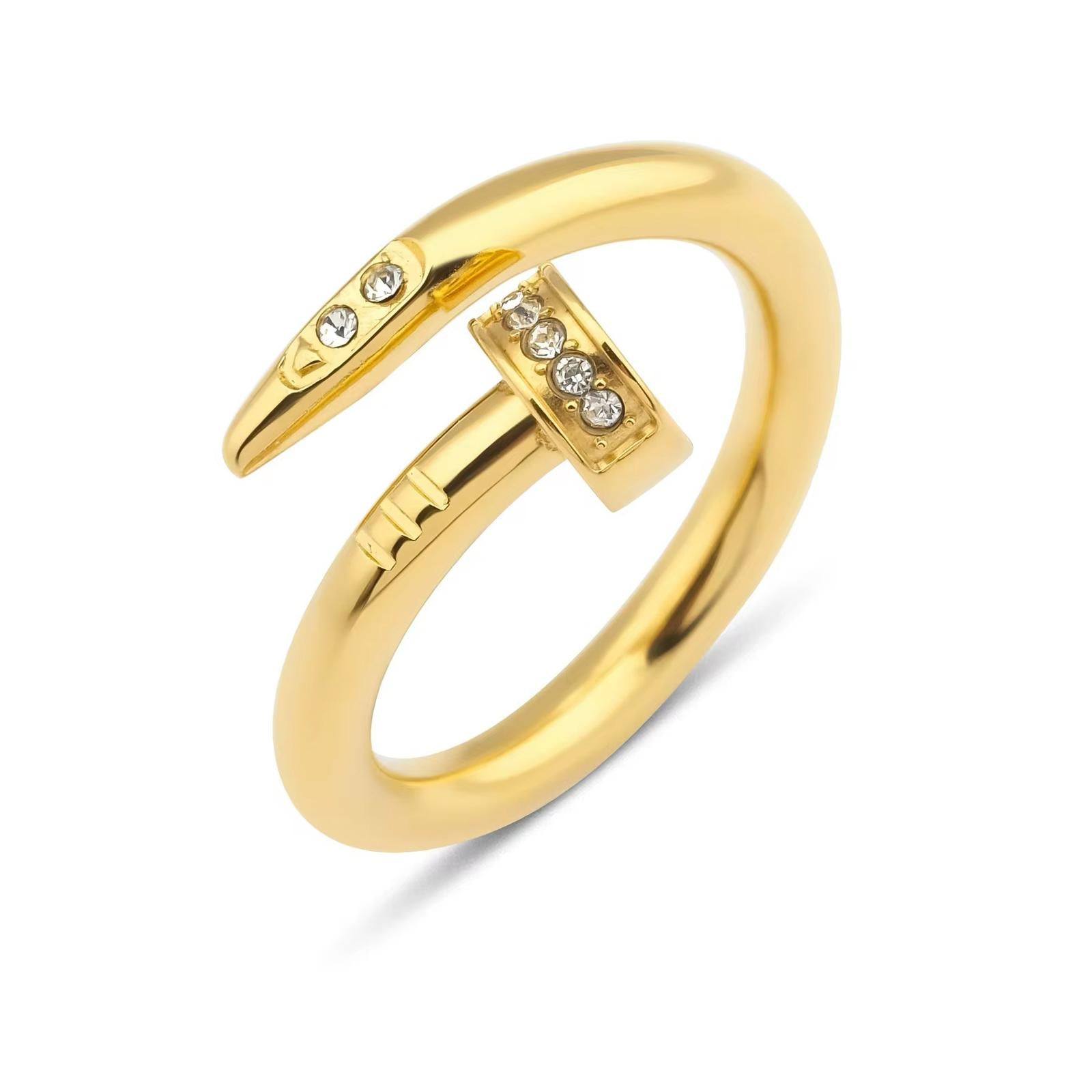 A gold-colored callie ring with a design resembling a nail and adorned with small cubic zirconia