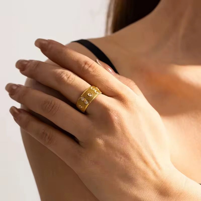 Gold cleo ring on a hand with a blurred background