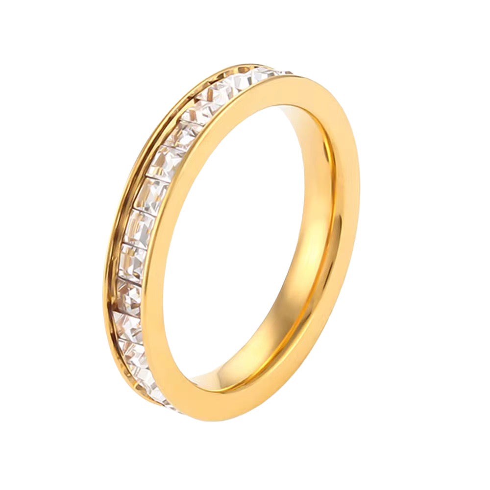 A gold-colored forever ring with zirconia stones set in a row around the band, displayed against a white background.