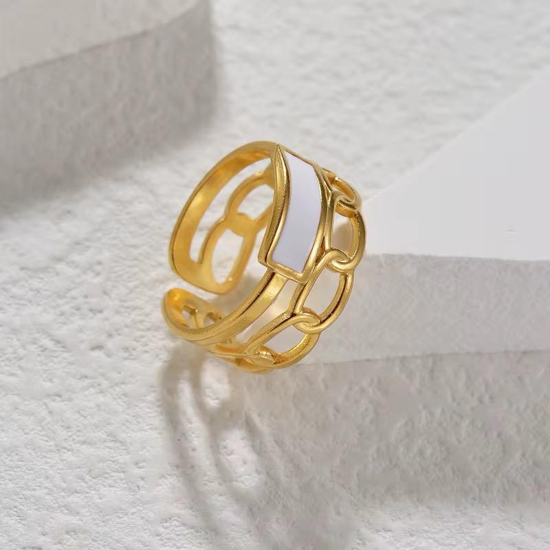 A gold-colored gia ring with an adjustable design, placed on a textured surface.