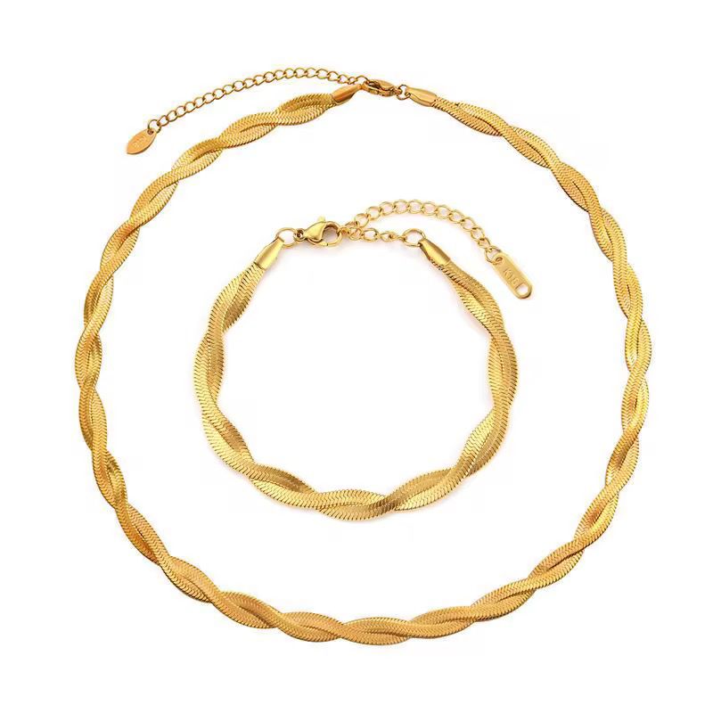 Gold necklace and bracelet set on a white background