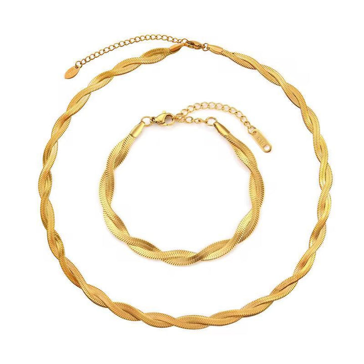Gold necklace and bracelet set on a white background