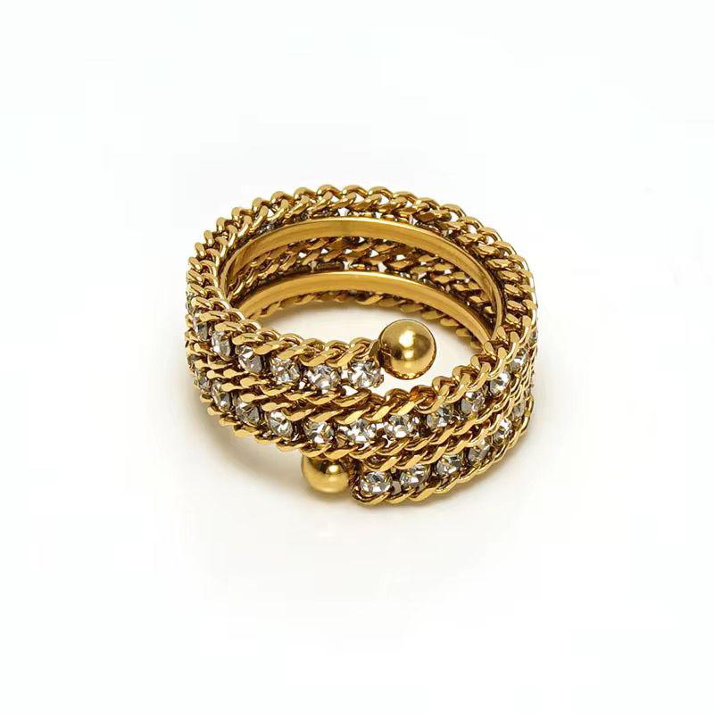 Gold rhinestone ring with chain design and embedded stones on a white background
