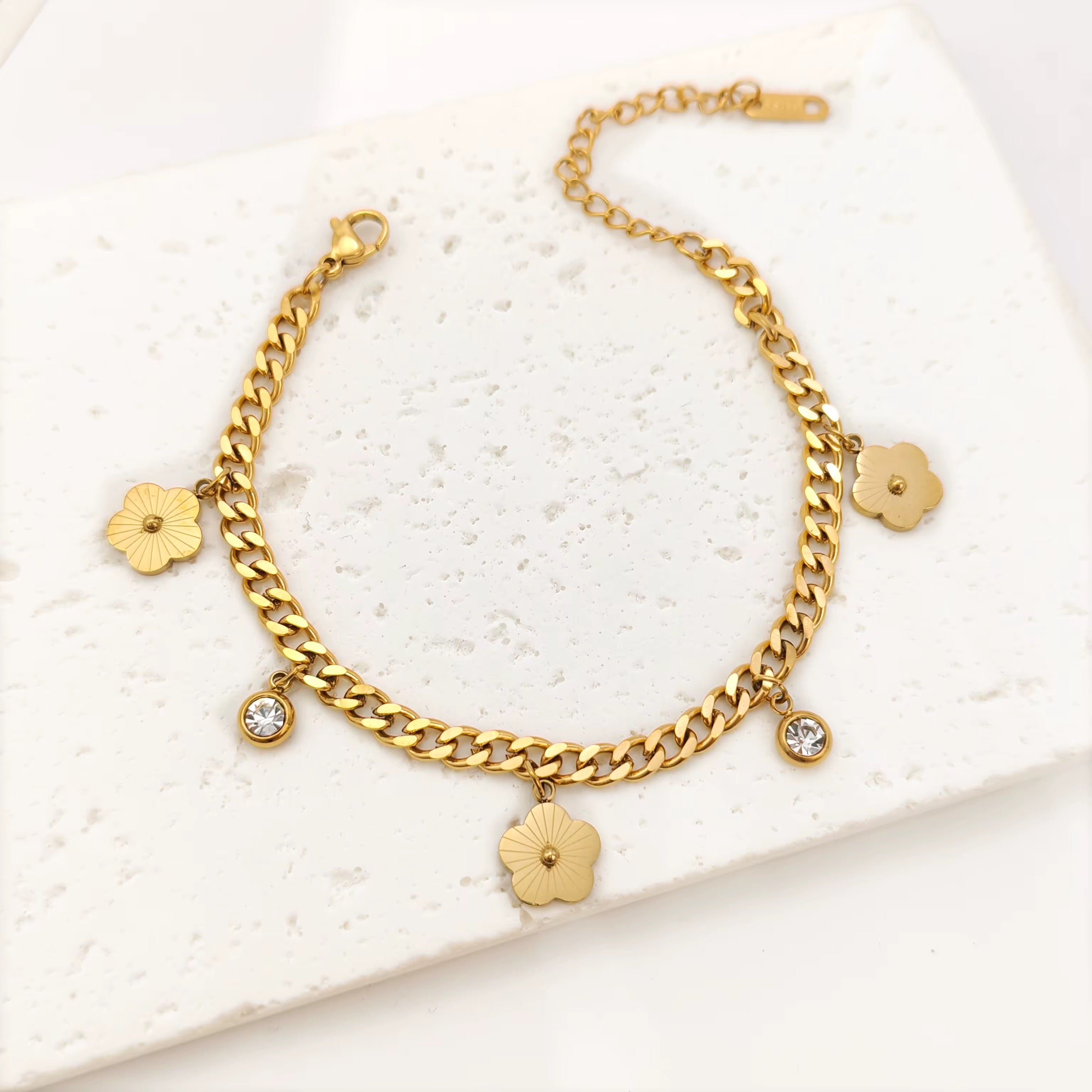 Gold roma double chain clover bracelet with floral charms on a white background