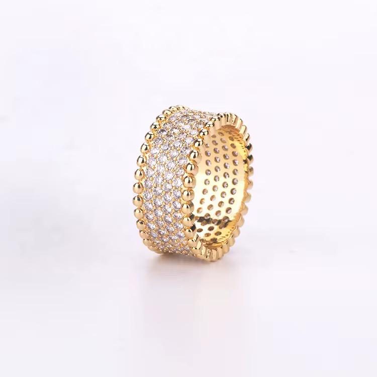 Gold zircon ring with intricate design on a white background