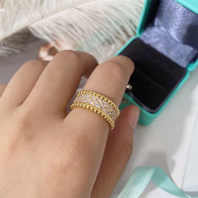 Gold zircon ring with diamonds on a hand, turquoise jewelry box in the background